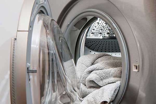 drying machine door open with freshly washed towels inside