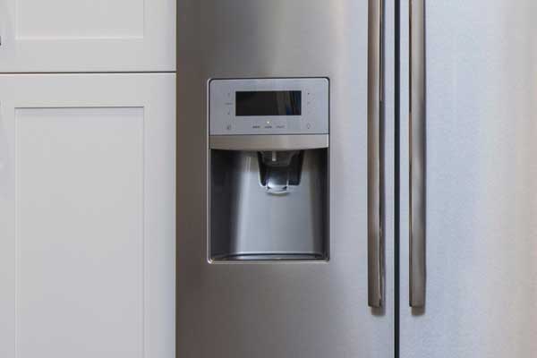 detail of ice maker on modern stainless steel refrigerator appliance