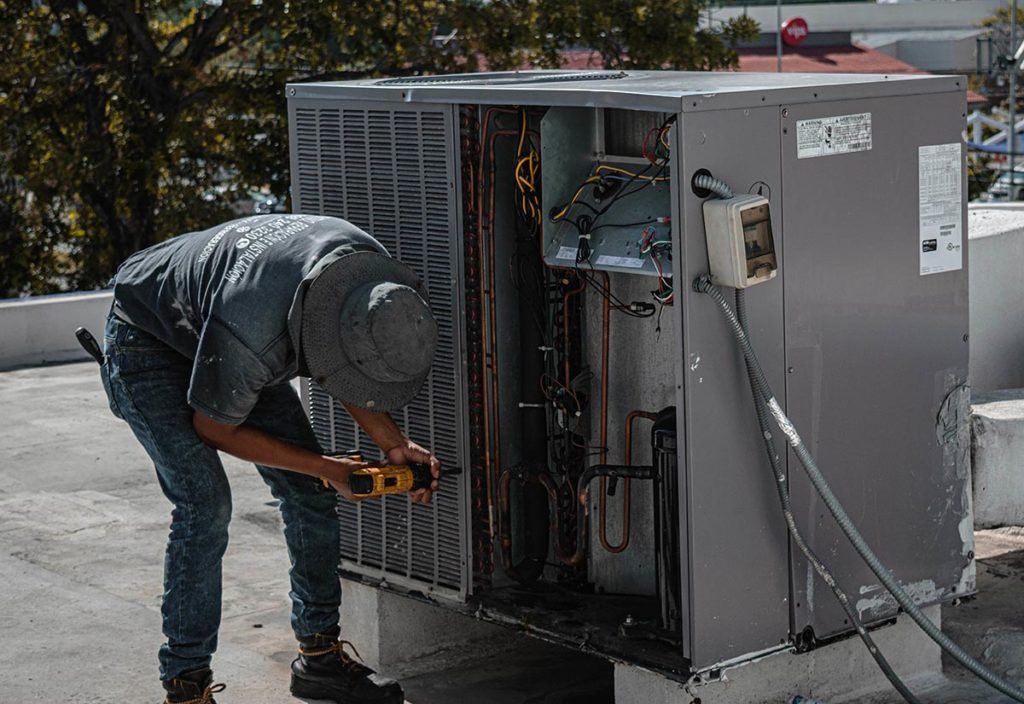 man performing hvac repair on roof